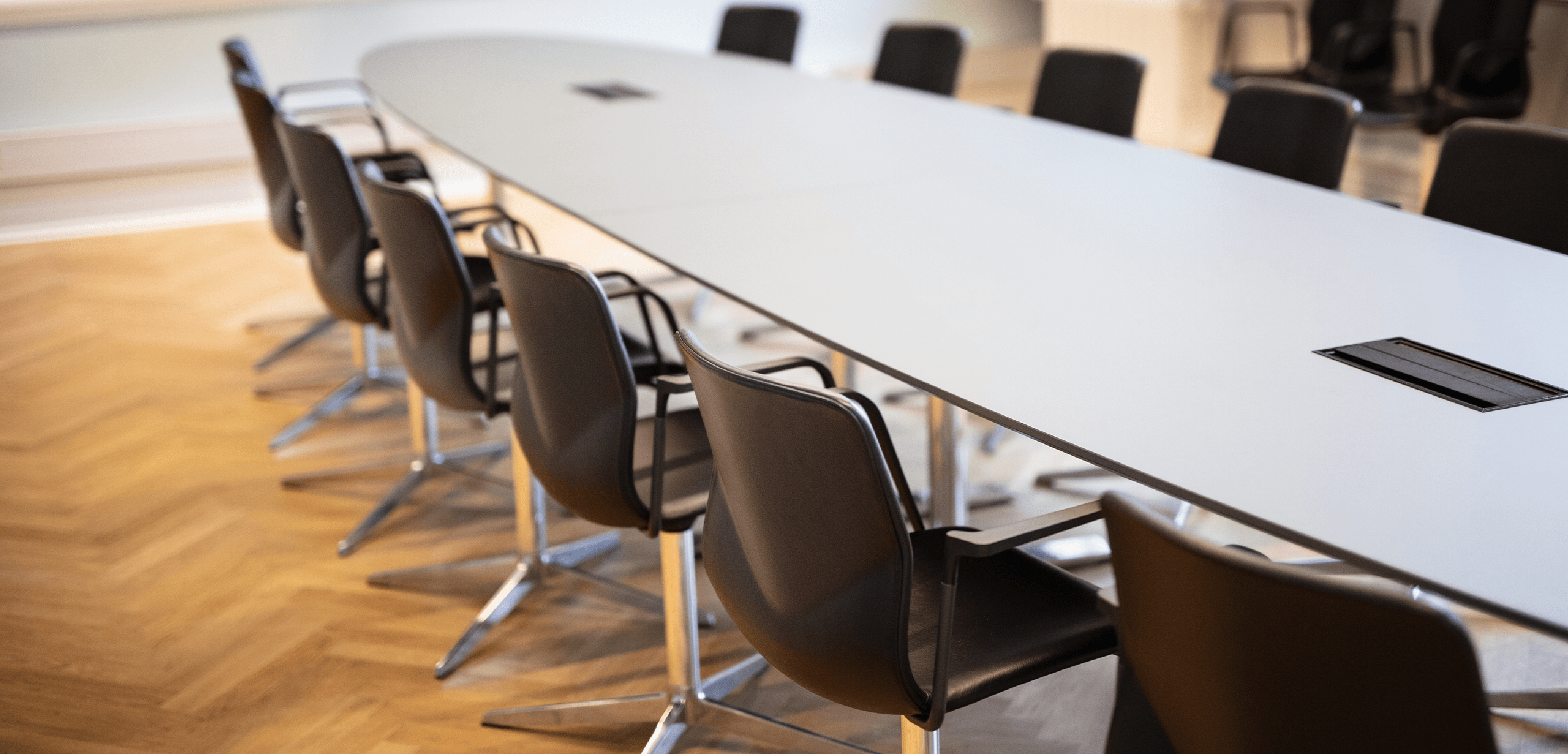 A conference room with a long designer office table and chairs.